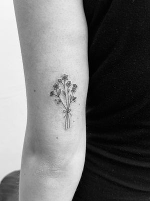Admire the intricate fine line work of this dainty illustrative bouquet tattoo by Timmy. Perfect for those who appreciate delicate floral designs.