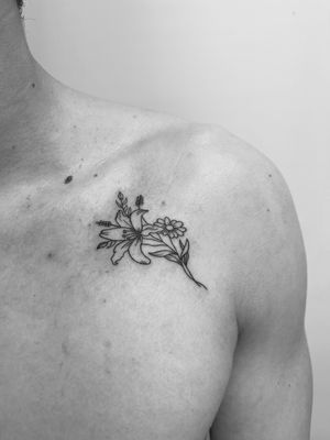 Elegant and delicate lily flower design expertly crafted in fine line style by tattoo artist Timmy.