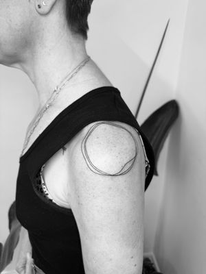 Elegant and minimalistic enso circle tattoo expertly crafted in fine line style by renowned artist Timmy.