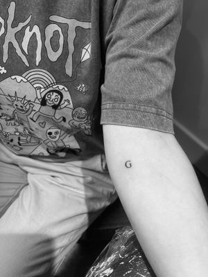 Express your individuality with this delicate small lettering tattoo by skilled artist Timmy. Perfect for a subtle yet meaningful statement.