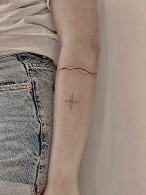 Experience intricate beauty with this dainty snowflake tattoo by Katerina Nireta. Perfect for lovers of ornamental art.