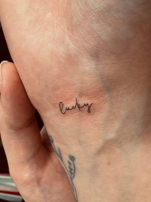A delicate fine line tattoo showcasing intricate small lettering, expertly done by the talented artist Katerina Nireta.