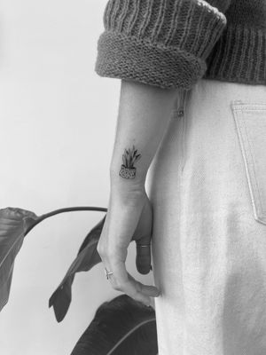 Unique illustrative tattoo featuring a beautiful vase and plant motif, created by the talented artist Timmy.