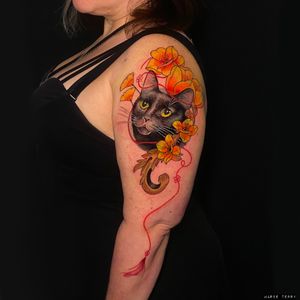 Marie Terry's stunning tattoo features a realistic cat surrounded by intricate filigree and delicate flowers.