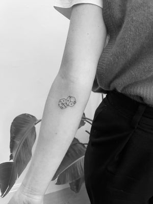 A unique dice tattoo designed in illustrative style by Timmy, showcasing creativity and precision in ink artistry.