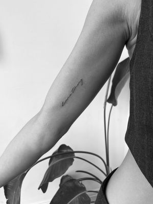 Get a stunning fine line tattoo with small lettering by the talented artist Timmy. Perfect for those looking for a subtle yet elegant design.