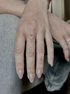 Elegant and dainty finger tattoo designed by Katerina Nireta. Intricate ornamental motif for a subtle and sophisticated touch.