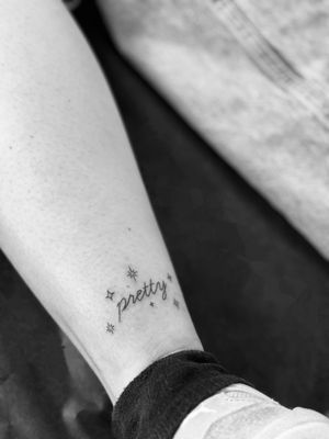 Elegant and detailed small lettering tattoo done by Timmy in a fine line style, perfect for those looking for a subtle yet meaningful design.