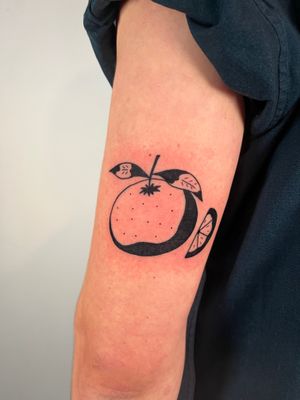 A stunning blackwork tattoo of a sliced orange, expertly crafted by artist Dave Norman.