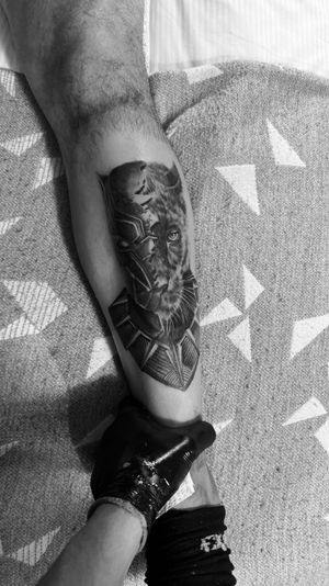 Experience the power and strength of the Black Panther with this stunning black and gray realism tattoo by Rollo.