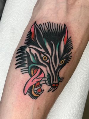 Get a timeless traditional wolf tattoo by the talented artist Clara Colibri. Bold lines and vibrant colors bring this fierce creature to life.