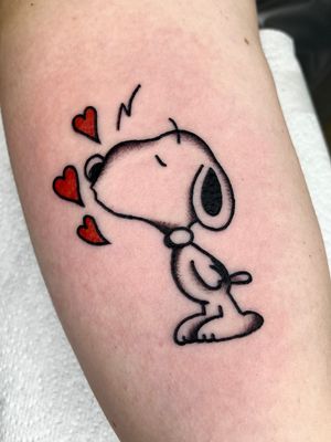 Illustrative tattoo by Clara Colibri featuring a heart, Snoopy character, and a kiss. Perfect for fans of classic cartoons!