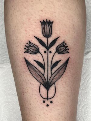 Get a stunning black and gray traditional flower tattoo that perfectly embodies the illustrative style, done by Clara Colibri.