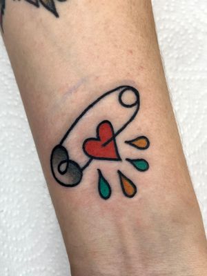 Get a unique tattoo by Clara Colibri featuring a heart, safety pin, and clothes pin. Perfect blend of traditional and illustrative styles