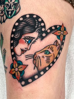 Admire the intricate details in this stunning traditional tattoo featuring a beautiful cat, lady portrait, and floral elements by Clara Colibri.