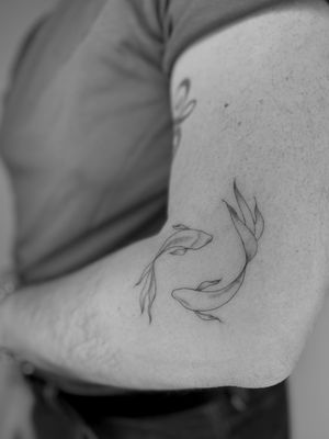 Embrace the beauty of the fine line and illustrative style with this delicate and dainty koi fish tattoo design by Ruth Hall.