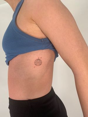 Get groovy with this fine line, illustrative tattoo of a delicate disco ball. Created by the talented artist Chloe Hartland.