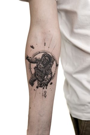 This black and gray illustrative tattoo features an astronaut skull and skeleton design by talented artist Alex Lloyd.