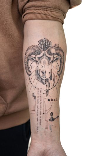 This small lettering, fine line tattoo features an illustrative design of a ram in a geometric style, expertly done by artist Alex Lloyd.