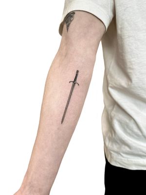 Intricately detailed micro-realism sword tattoo by Alex Lloyd, adding a touch of mystery and elegance.