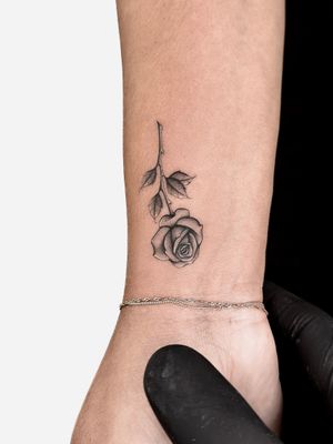 Illustrative flower tattoo by Alex Lloyd, capturing the timeless beauty of a rose in stunning black and gray ink.