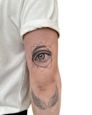 Stunning black and gray fine line tattoo by Alex Lloyd, featuring a micro-realism eye inside a geometric frame design.