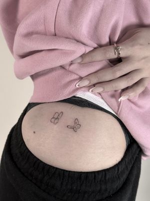 Get a dainty butterfly tattoo by Saka Tattoo. This fine line design exudes elegance and sophistication.