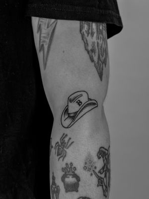 Get a timeless Western vibe with this illustrative cowboy hat tattoo. Expertly done by artist Oliver Soames.