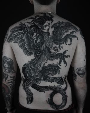 Embrace the darkness with this blackwork, illustrative harpy monster tattoo inspired by medieval folklore. Let Lukey Wolf bring this mythical creature to life on your skin.