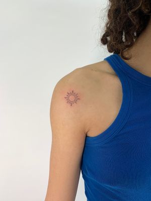Get a stunning fine line and illustrative tattoo of a delicate and dainty sun design by the talented artist Chloe Hartland.