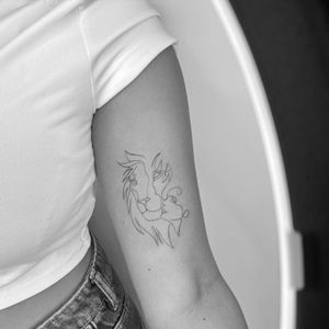 Stunning fine line tattoo featuring a majestic lion and a girl, beautifully illustrated by the talented artist Ruth Hall.