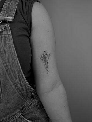 Elegantly crafted fine line tattoo featuring a beautiful tulip bouquet, intricately designed by tattoo artist Ruth Hall.
