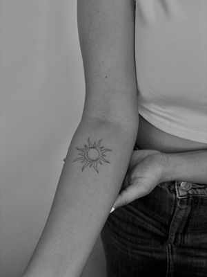 Delicate & dainty tattoo featuring a fine line design of a sun and moon by Ruth Hall.