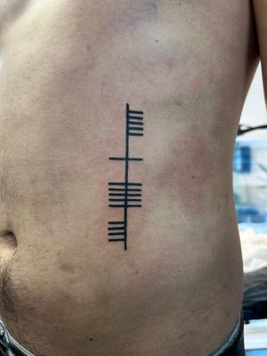 Unique blackwork tattoo featuring traditional Irish Ogham script, expertly done by artist Jonathan Glick.