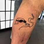 Get a unique ignorant style tattoo featuring a smoking dog doodle, created by the talented artist Jonathan Glick.