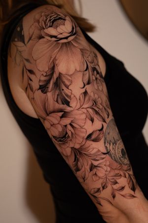 Elegant flower motif tattoo by Ion Caraman, featuring intricate fine line details in a floral design.