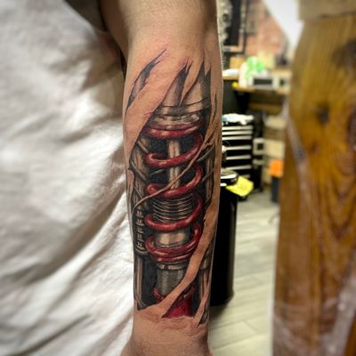 Full colour realism tattoo of a Mustang shock absorber embedded within the skin