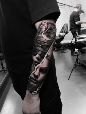 Black and gray illustrative tattoo of a lady holding a scale, symbolizing justice, by artist Santy Taiga.