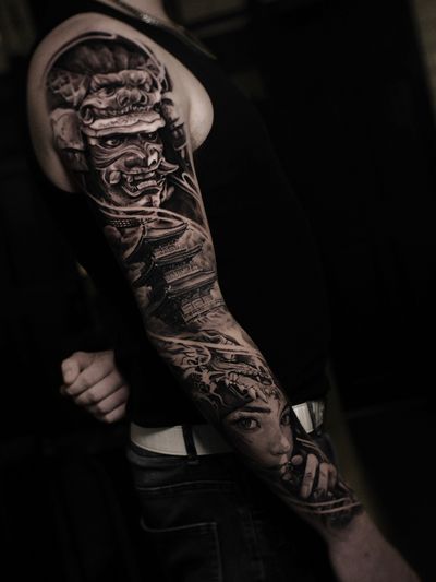 Stunning realism tattoo featuring a samurai in a mysterious setting with a pagoda and ninja mask. By Santy Taiga.