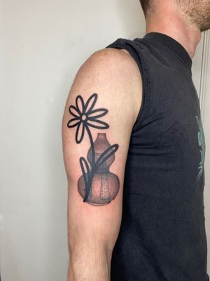 Charlie Macarthur's intricate black and gray tattoo features a stunning flower blooming from a decorative vase.