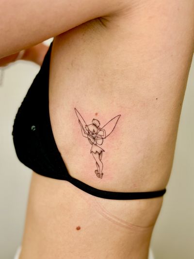 A black and gray illustrative tattoo of Tinker Bell, the beloved Disney fairy, done by artist Ruth Hall. Delicate and detailed design.