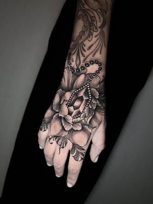 Get a stunning dotwork tattoo featuring a beautiful flower and intricate jewel design by the talented artist Hamid.