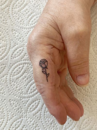 Laura's fine line hand-poked rose tattoo in an elegant and minimalistic style.