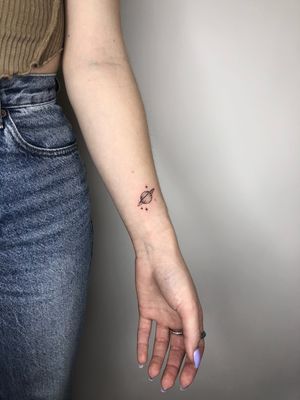 Micro-realism tattoo of Saturn with sparkles in black and gray by Winnie Shwe.