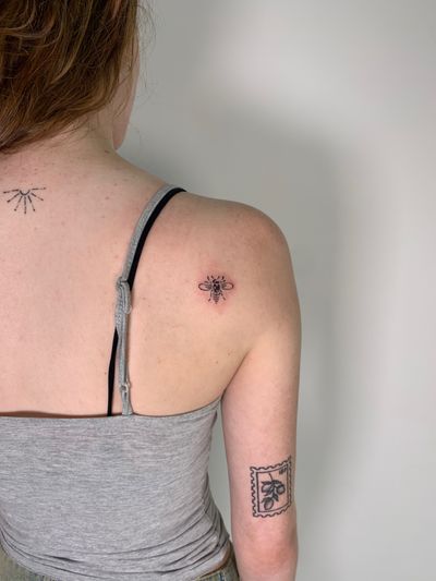 Unique blackwork tattoo of an abstract bee design by Chloe Hartland, perfect for those looking for a bold and artistic piece.