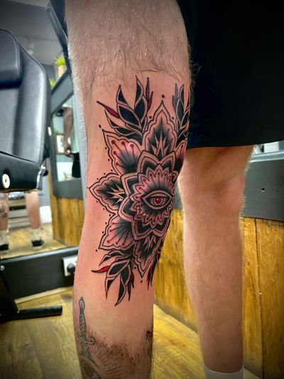 Beautiful traditional tattoo featuring a vibrant flower and all-seeing eye, skillfully done by Alex Snowden.