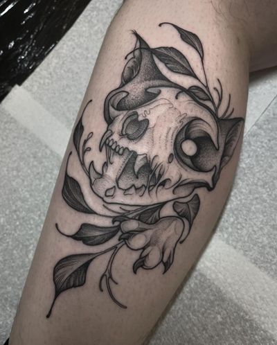 Illustrative tattoo featuring a cat, tree, skull, and branch, expertly done by Claudia Smith.