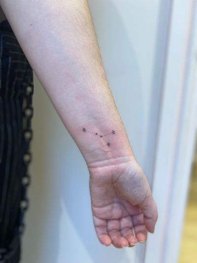 Fine line ornamental tattoo by Alfonso Barberio, featuring a delicate and dainty constellation motif.