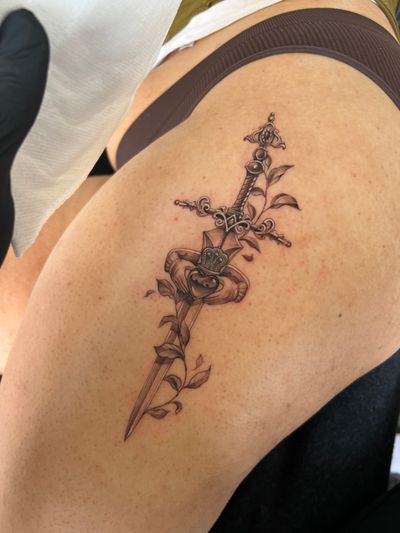 Experience the beauty of micro-realism with this black and gray tattoo featuring a detailed heart, sword, and vine motif. Created by the talented artist Ion Caraman.