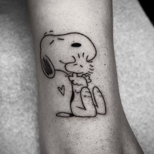 Get this adorable illustrative tattoo by Barbara Nobody featuring Snoopy and Woodstock from Peanuts. Perfect for fans of the beloved comic strip!